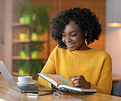 a student smiling reading a book